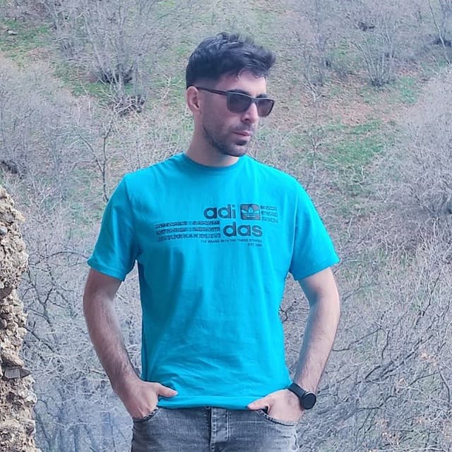 Hussein standing outdoors in a turquoise shirt