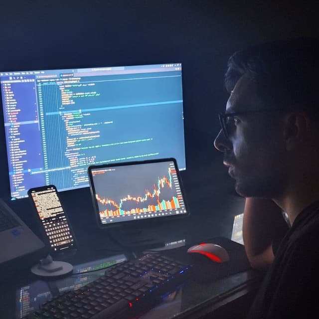 Hussein working at a multi-monitor development setup